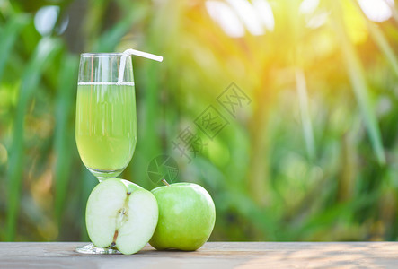 绿色苹果汁在玻璃和切苹果水中的绿色苹汁具有自然绿色夏季背景选择焦点图片