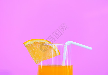 夏季橙汁以粉红背景的玻璃杯中橙子果有选择地聚焦图片