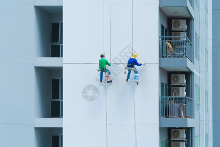 一群人工或画家中午在曼谷市心外的一座高楼上挂墙图片