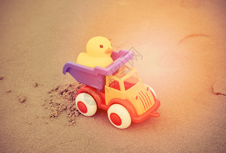 黄鸭玩具和彩色汽车在沙滩上孩子们节日快乐高清图片