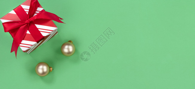 绿色背景有圣诞礼物盒和金装饰品图片