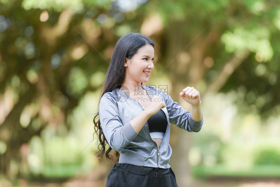 亚洲女拳击手保持身体运动在花园里拉伸肌肉健康微笑的年轻女孩在公园背景的户外快乐女人身上放松运动图片