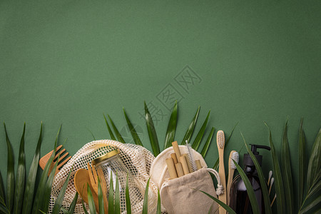 零废物概念棉花袋竹栽培玻璃罐竹牙刷梳子和草根绿色背景平板纸质文本复制空间无塑料可持续生活方式概念零废物棉花袋毛刷和绿背景稻草图片