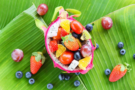 香蕉叶本底的夏季热带水果沙拉碗用于龙和蔬菜健康有机食品图片