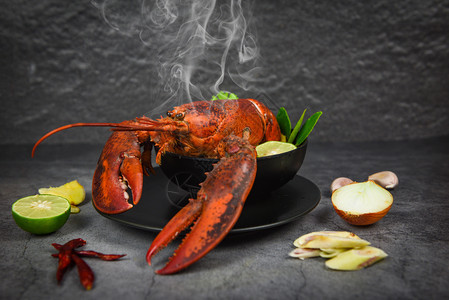 红龙虾辣汤碗煮海鲜配有龙虾晚饭桌和黑盘口味食品香料图片