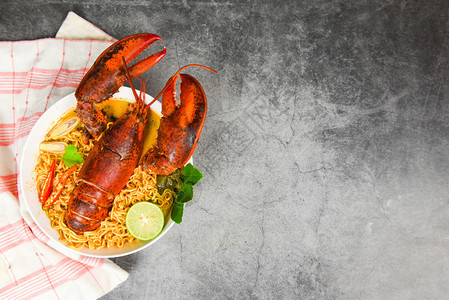 面条碗龙虾辣汤面条龙虾晚餐桌和黑盘口味食品的香料图片
