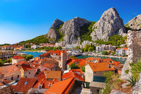 克罗地亚非常受欢迎的旅游点奥米斯老城的Cetina河山峰和红屋顶克罗地亚Sunny镇和奥米斯港图片