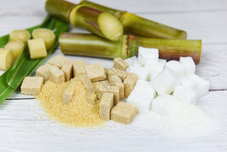 白糖和棕色立方木制桌底的甘蔗图片