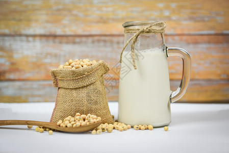 白碗上的豆和干玻璃罐中的奶用于健康饮食料和天然豆蛋白图片