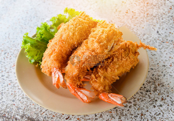 美味的深油炸虾烤盘子上有蝴蝶虾顶端生菜图片
