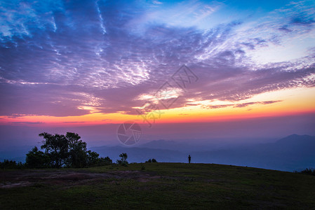 在山顶的美丽天空日落或出云彩色多蓝紫黄的天空暮光山顶的风景图片
