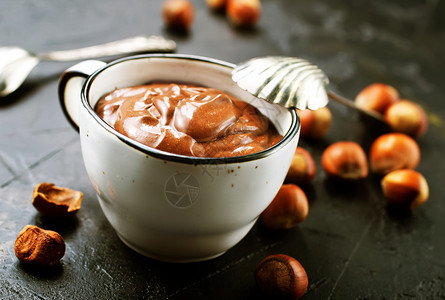 土制的栗子扩散或热巧克力与坚果和巧克力棒的杯子图片