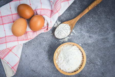 灰色背景的木碗面粉厨房桌上的自制面粉鸡蛋烹饪素材图片
