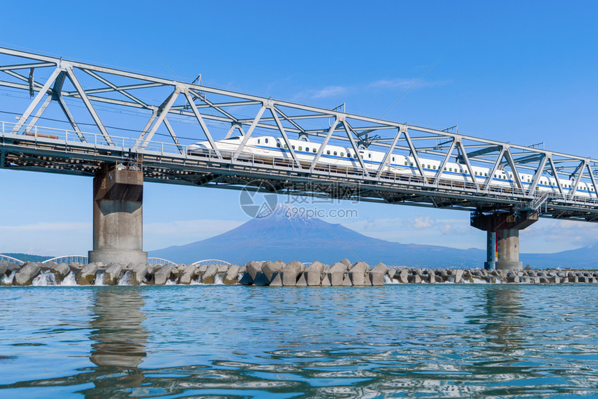 Shinkansen列车快速驾驶和经过东京火车站附近的藤田山在日本静冈富士河上架着钢桥图片