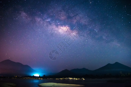 银河系流和光亮深夜空中山地背景图片