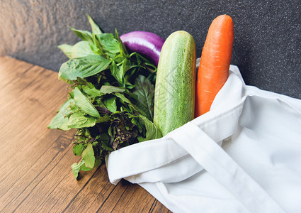 零废物使用较少塑料概念在木制桌上的生态棉花布袋中使用新鲜蔬菜有机制品市场免费塑料购物的白色拖布袋图片