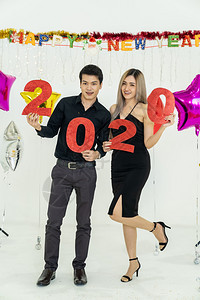 参加20年红牌派对的轻夫妇庆祝新年快乐图片