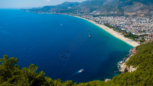 Alanya海滨山顶风景岸渡船在蓝上以及港湾城市背景美丽的cleopatra海滨Alanya土耳其风景旅游标志图片