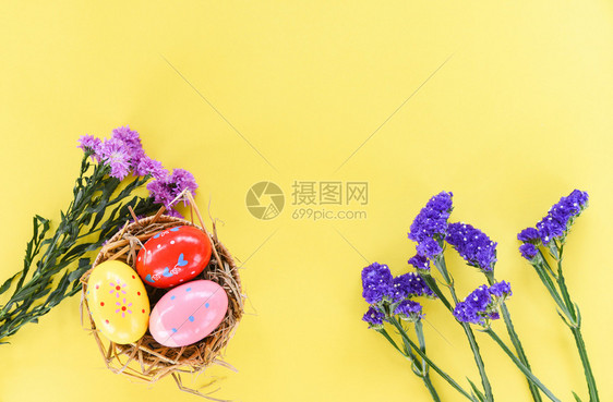 带紫花和黄色背景的静态花篮子巢装饰复活节鸡蛋图片