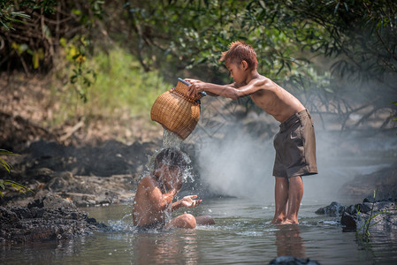 河上亚洲儿童男孩朋友在农村活生的民儿童的河水中玩乐图片