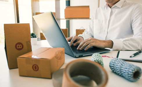 企业家们正在通过办公室打信息键盘笔记本电脑对客户产品进行订购图片