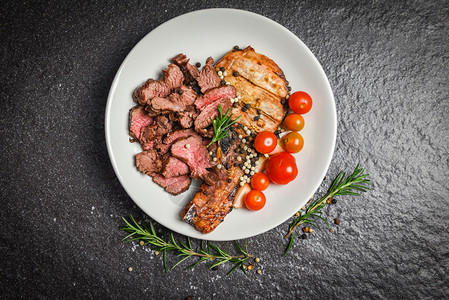 黑底牛肉排和草药香料迷迭在盘子上，好吃图片