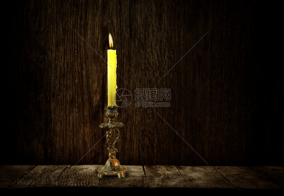 在木暗背景上用燃烧蜡烛烤的RetroCandelabra图片