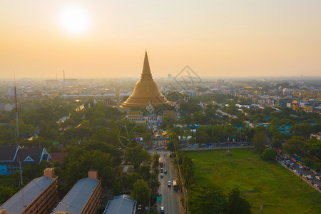 日落时的法拉路德玛迦迪寺庙空中最顶端景象带有住宅的金佛塔泰国纳科恩路德姆区城市圣泰建筑图片