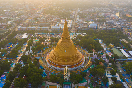 日落时的法拉路德玛迦迪寺庙空中最顶端景象带有住宅的金佛塔泰国纳科恩路德姆区城市圣泰建筑图片