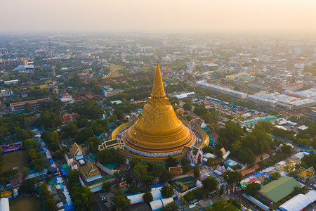 日落时的法拉路德玛迦迪寺庙空中最顶端景象带有住宅的金佛塔泰国纳科恩路德姆区城市圣泰建筑图片