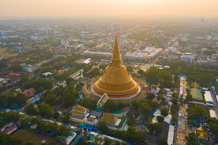 日落时的法拉路德玛迦迪寺庙空中最顶端景象带有住宅的金佛塔泰国纳科恩路德姆区城市圣泰建筑图片