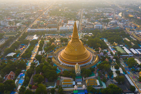 日落时的法拉路德玛迦迪寺庙空中最顶端景象带有住宅的金佛塔泰国纳科恩路德姆区城市圣泰建筑图片