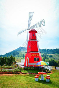 花园公红风车力涡轮机台椅上挂有多彩雨伞咖啡店户外和山地背景图片
