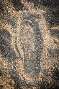 沙子上的鞋轨脚质背景地面痕迹上的印足图片