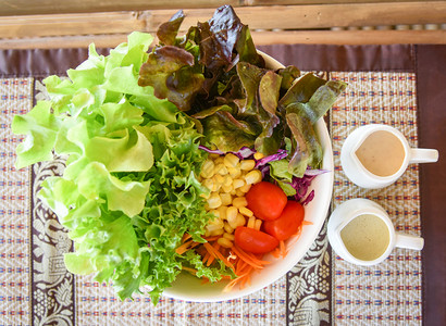 新鲜沙拉碗水养菜蔬配有绿橡皮生菜红树玉米胡萝卜卷心菜红番茄紫片和沙拉酱杯图片