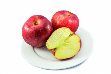 红苹果水和切片半在白底盘上隔绝图片