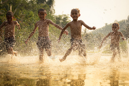 生活在农村的儿童民在水中奔跑图片