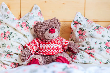 可爱的泰迪熊玩具坐在床上早醒来图片