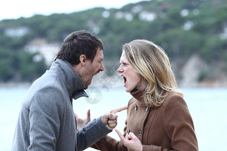 愤怒的男女在冬天海滩上争吵和互相喊叫图片素材