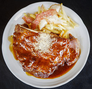 黑底牛肉排和草药香料迷迭在盘子上，好吃图片