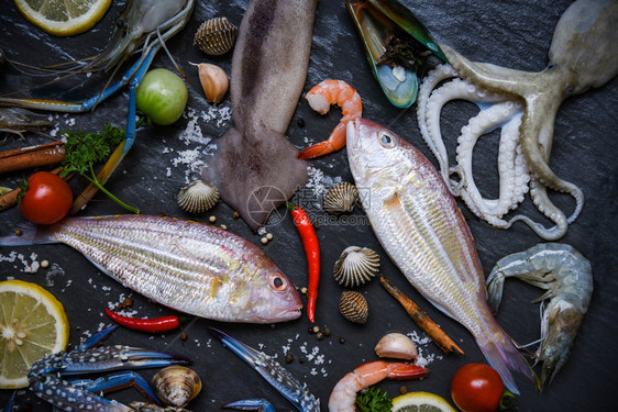 底黑含草菜和香料柠檬的新鲜海菜产食品板外壳虾蟹图片