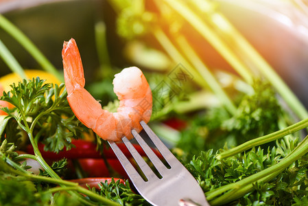 叉上的虾煮海鲜配有草药和香料的叉海洋美食晚宴图片