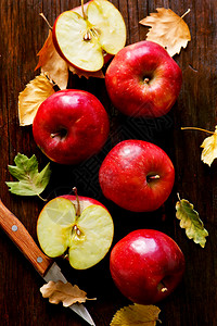 木制桌上的红苹果和刀图片