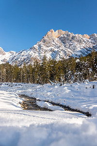 荒冬的季风景惊人的山脉美丽河流雪树和蓝天空图片