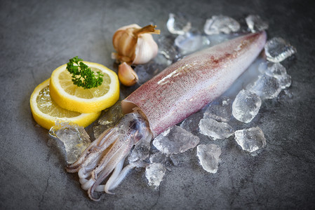 在冰上生鱿鱼深板背景新鲜乌贼章鱼或餐饮海鲜市场煮熟食品的甲头鱼图片