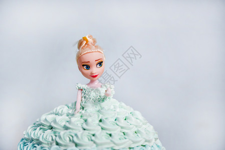 蓝奶油蛋糕娃婚礼或女孩生日的蛋糕灰色背景图片