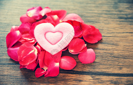 情人节爱心浪漫概念玫瑰花瓣的皮囊粉红心被装饰在木桌生锈的背景上图片