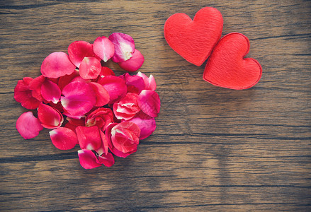 情人节爱心概念玫瑰花瓣的堆叠红心花瓣装饰在木桌生锈背景上图片