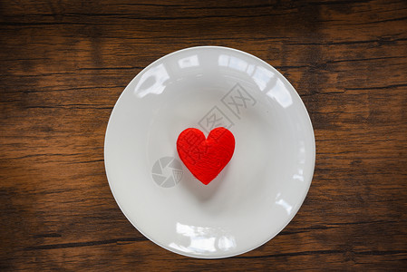 红心背景红心放在白色盘子的浪漫桌上装饰着红心的木质纹身背景背景