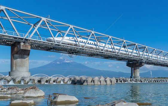 Shinkansen列车快速驾驶和经过东京火车站附近的藤田山在日本静冈富士河上架着钢桥图片